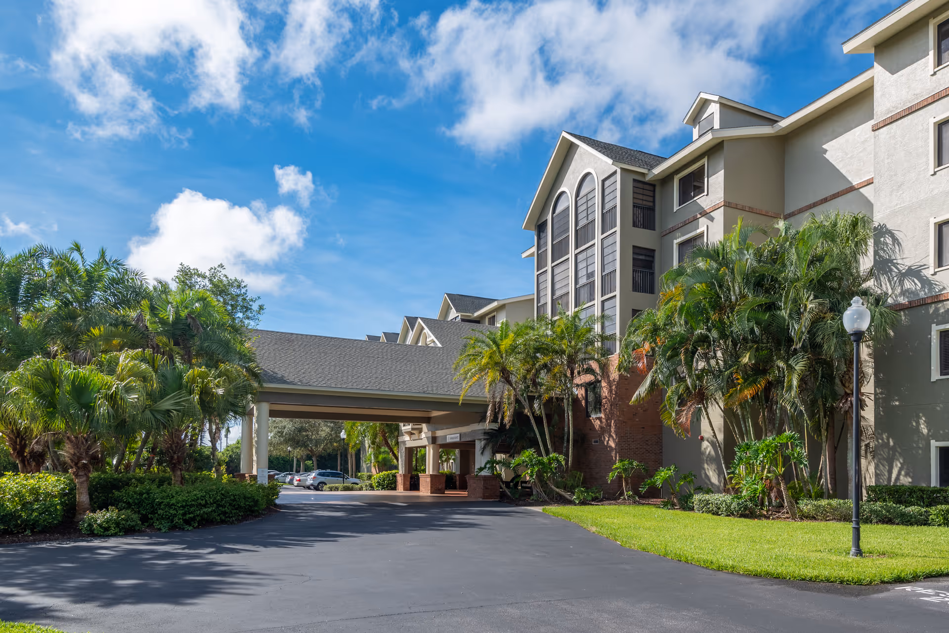 Exterior view of South Port Square building with palm trees and a covered entrance.