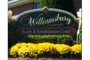 Exterior Williamsburg Health & Rehabilitation Center sign with bright yellow flowers.
