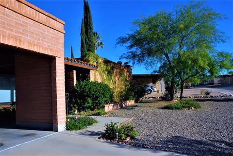 Exterior view of Casa Jorge Adult Care with brick walls and desert landscaping