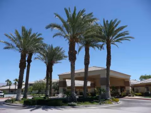 Atria Rancho Mirage exterior with tall palm trees and a covered entrance.