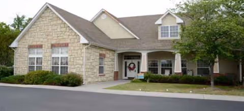 Stone-faced senior living facility exterior with a welcoming entrance and manicured landscaping.