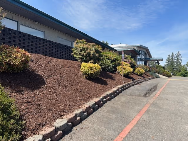 Exterior view of Renton Health and Rehabilitation facility with landscaped shrubs and mulch.