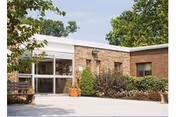 Exterior view of Autumn Lake Healthcare at Homewood Center entrance with brick walls and greenery.