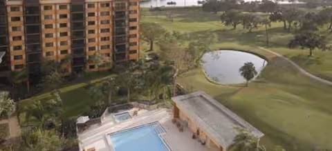 Exterior view of Elison Senior Living of Pinecrest with pool, lawn, and surrounding trees