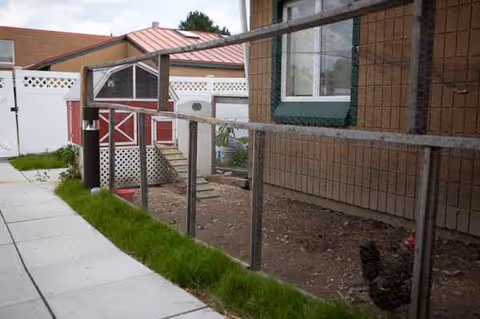 Exterior view of Lakewood A Continuing Care Center showing a fenced yard and walkway.