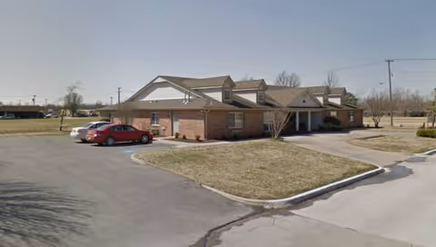 Single-story brick senior living facility with a front parking lot.