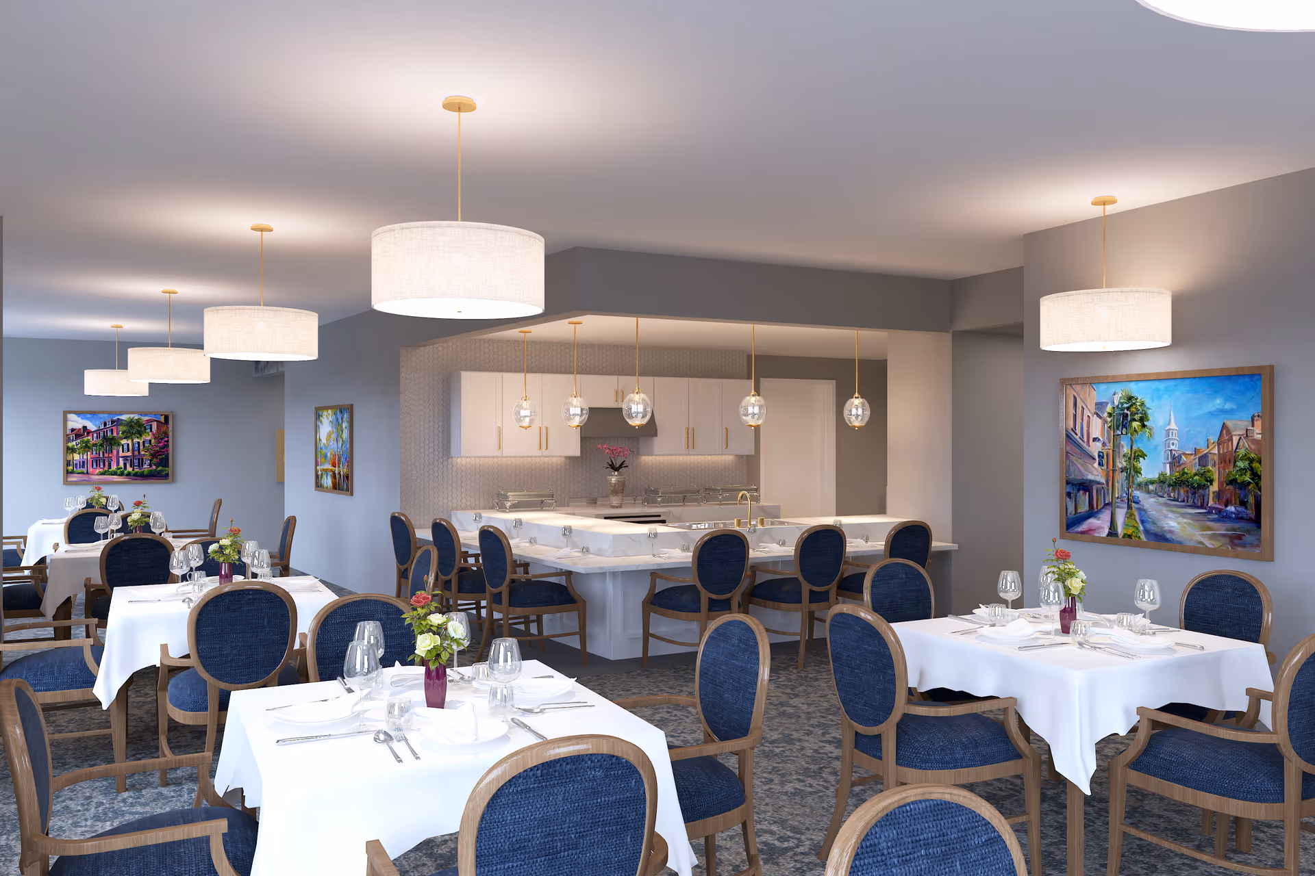 A bright and elegant dining room with multiple tables covered in white tablecloths, each set with glassware, plates, and silverware. The chairs have wooden frames with blue upholstered seats and backs. The room features modern pendant lights hanging from the ceiling and colorful paintings on the walls. In the background, there is a kitchen area with white cabinetry and a marble countertop with additional seating.
