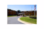 Exterior view of Good Shepherd Community facility with curved driveway and main entrance.