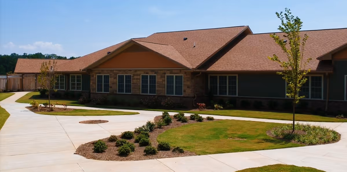 Single-story building with a landscaped lawn and curved concrete walkways under a blue sky.