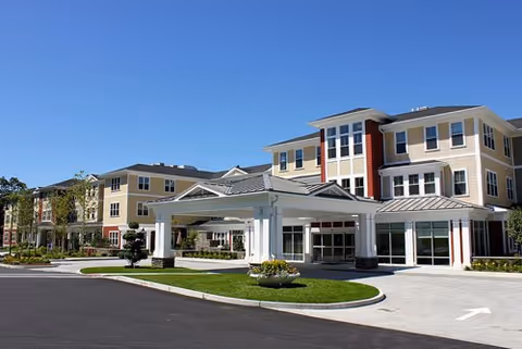 Exterior view of Wingate Residences at Needham showing the building entrance and driveway