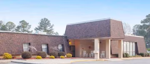 Front exterior of Mount Olive Center with a covered entrance and landscaped shrubs.