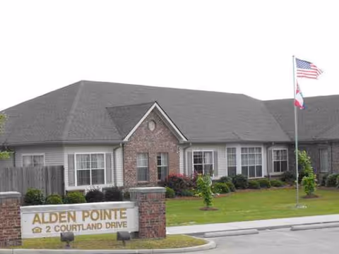Exterior view of Alden Pointe Assisted Living front with manicured lawn and sign.