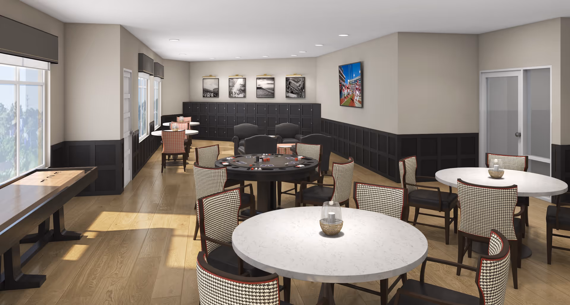 Bright common activity room with round tables and chairs, a shuffleboard table by the window, and a central gaming table.