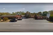 Exterior view of Cave Creek Assisted Living building with a parking lot.