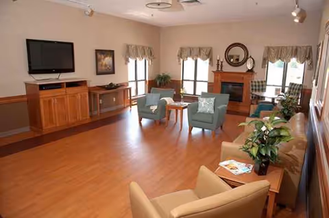 Spacious lounge in Laurels of New London with seating and a fireplace.
