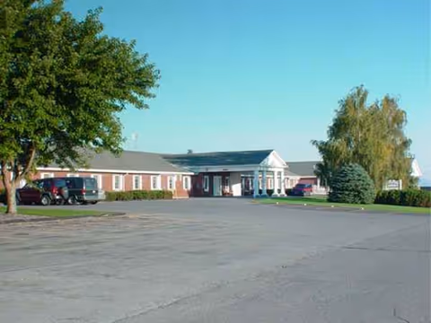 Exterior view of Caribou Rehab and Nursing Center with parking lots and trees.