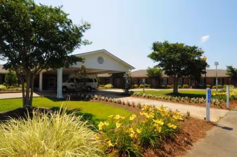 Exterior view of The Columns Rehabilitation and Healthcare Center with a landscaped entrance and parking area.
