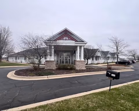 Front entrance of Dimensions Living Winnebago senior living facility with porte-cochere and curved driveway.