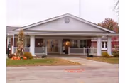 Front view of a single-story senior living facility with a covered porch and columns.