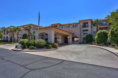 Exterior view of The Woodmark at Sun City entrance with flagpole and manicured landscaping.