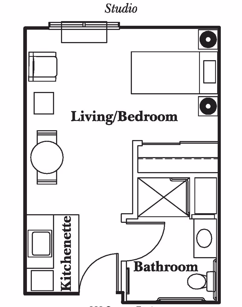 Floor plan of a studio apartment at Heritage Woods Of Centralia showing a combined living and bedroom area with a bed, two nightstands, a chair, a small table with two chairs, a kitchenette with a sink and stove, and a separate bathroom with a shower, sink, and toilet.