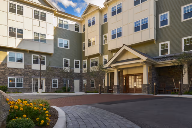 Exterior view of Brightview Arlington senior living facility entrance with walkway and landscaping.
