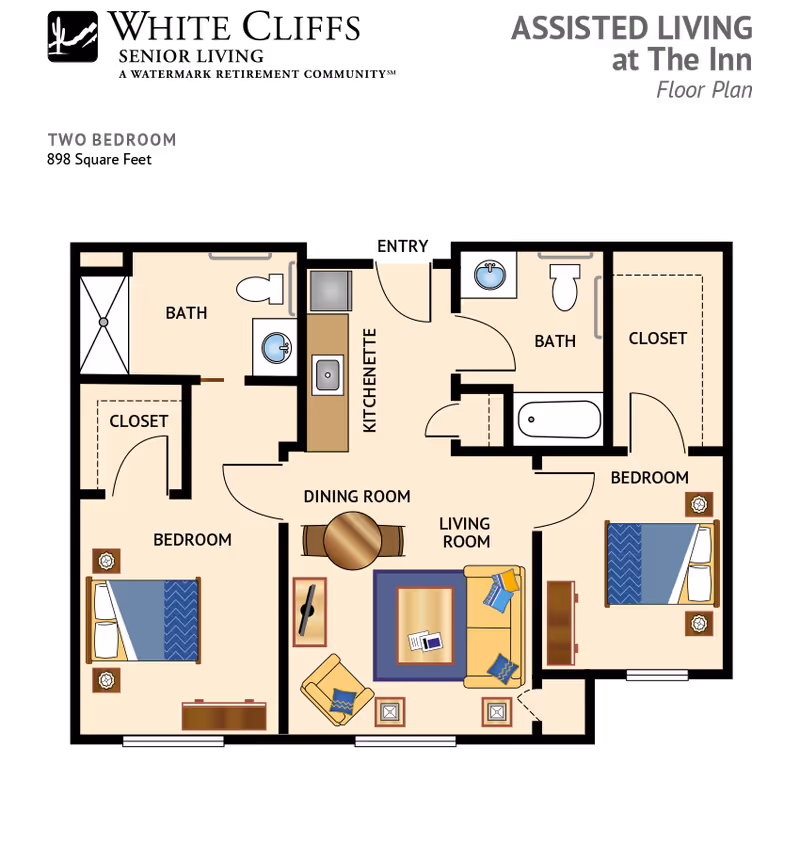 Floor plan of a two-bedroom assisted living apartment at The Inn, showing two bedrooms each with a closet, two bathrooms, a kitchenette, a dining room with a round table and four chairs, and a living room with a sofa, armchair, coffee table, and side tables.