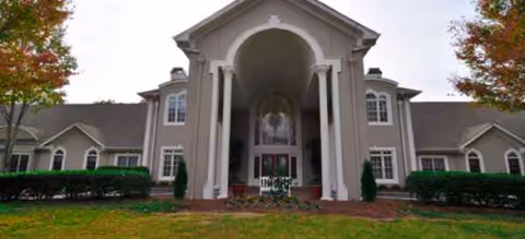 Front view of Regency House of Buford with arched entrance and landscaped lawn