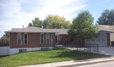 Brick single-story facility with ramp and green lawn in front