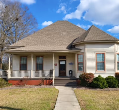 Quaint house-style senior care home with a front porch and walkway.