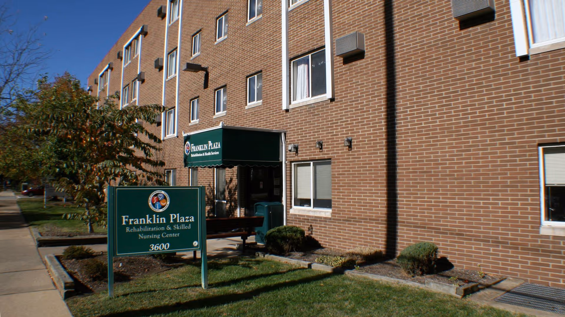 Brick senior living building with Franklin Plaza sign and entry canopy.