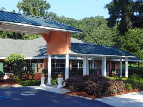 Front exterior of Hampton Manor Assisted Living at Belleview with covered entrance and landscaping.
