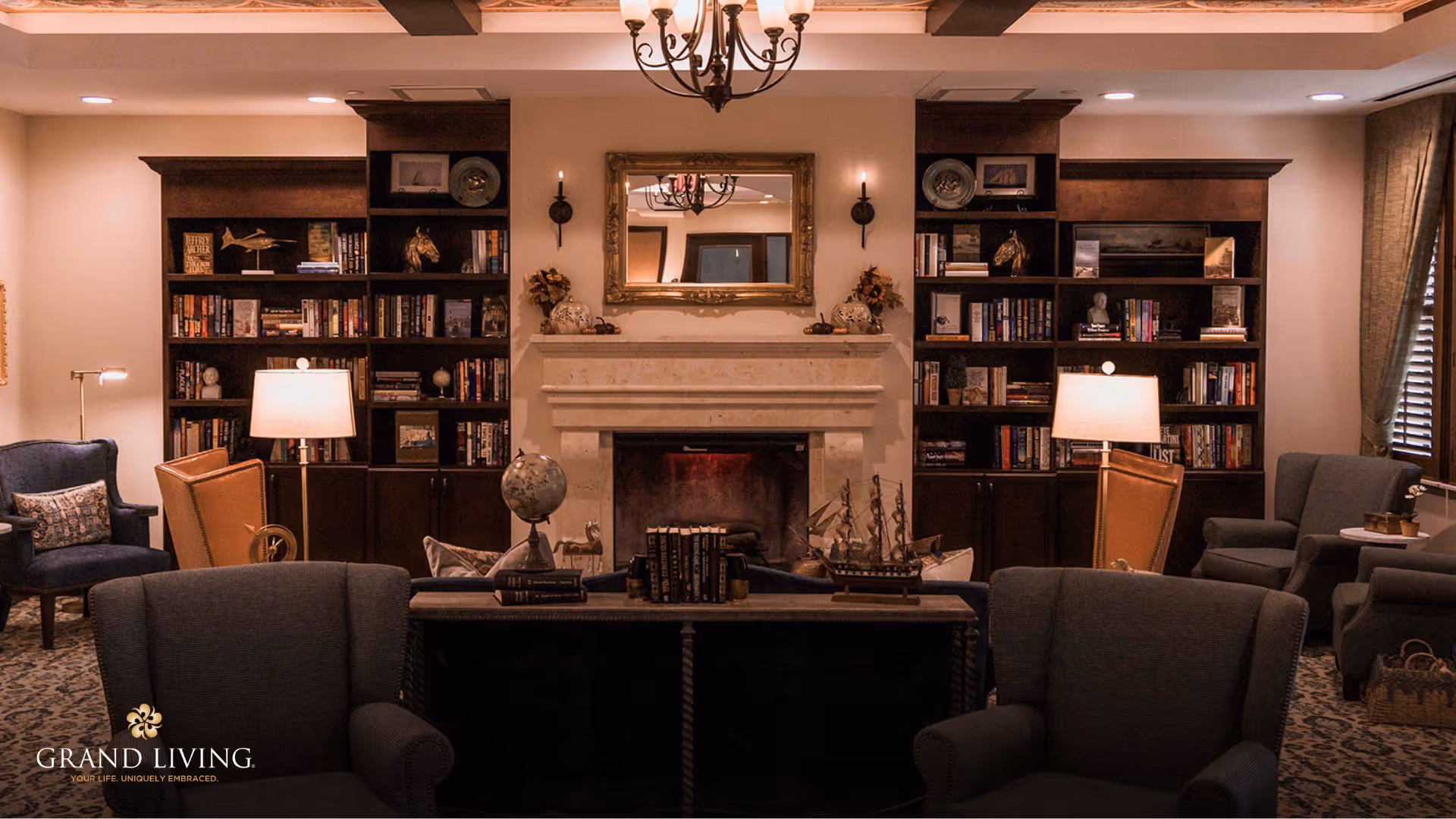 Cozy library-style lounge with a central fireplace flanked by built-in bookshelves, armchairs, and lamps.