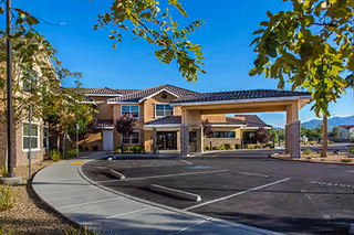Front exterior view of Marquis Care at Centennial Hills with a covered entrance and parking.
