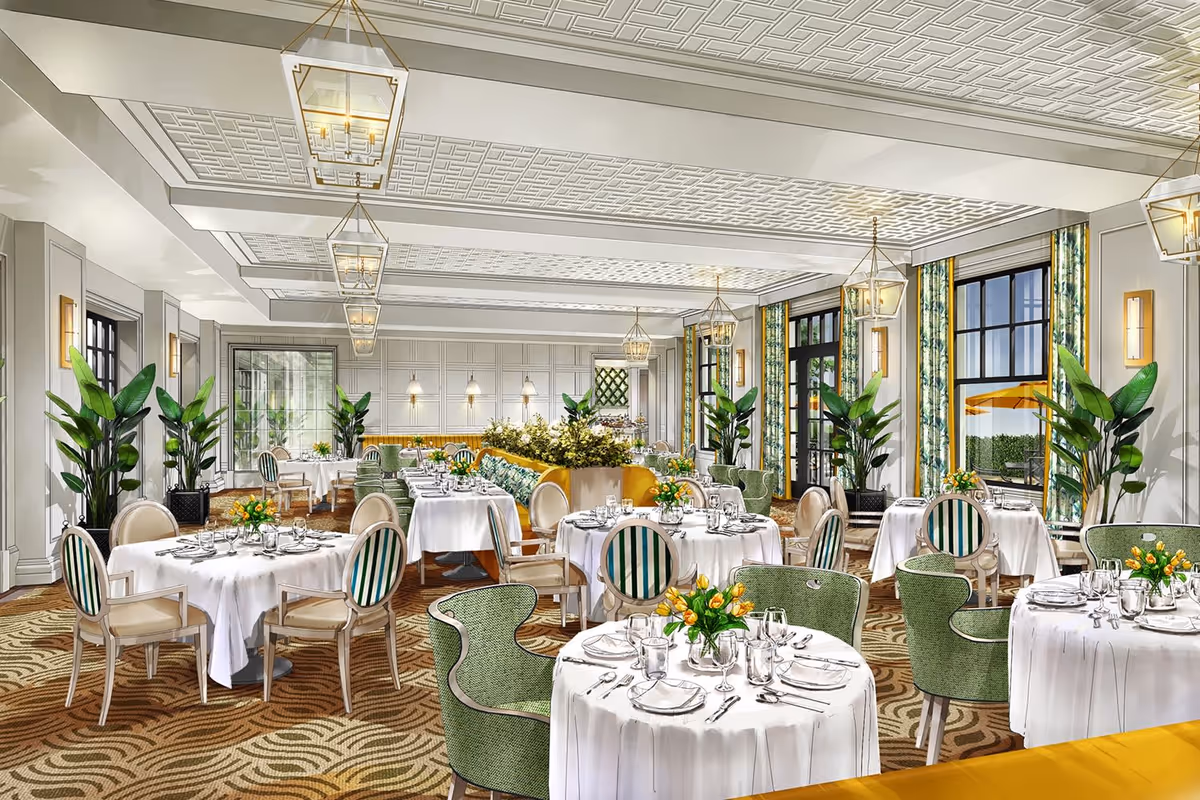 A spacious and elegant dining room with round tables covered in white tablecloths, set with plates, glasses, and silverware. The room features a patterned carpet, green upholstered chairs, and striped chairs. Large windows with floral curtains allow natural light to enter, and there are several potted plants and floral centerpieces on the tables. Modern pendant lights hang from a decorative ceiling.