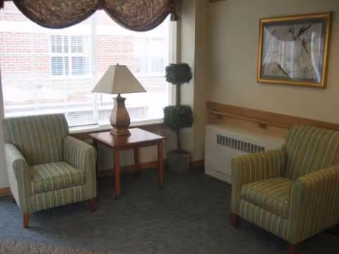 Parkview Health Center lounge with two green striped armchairs, a lamp, and window view.
