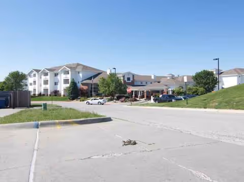 Front exterior of Fountain View Senior Living with cars parked and a clear street in view.
