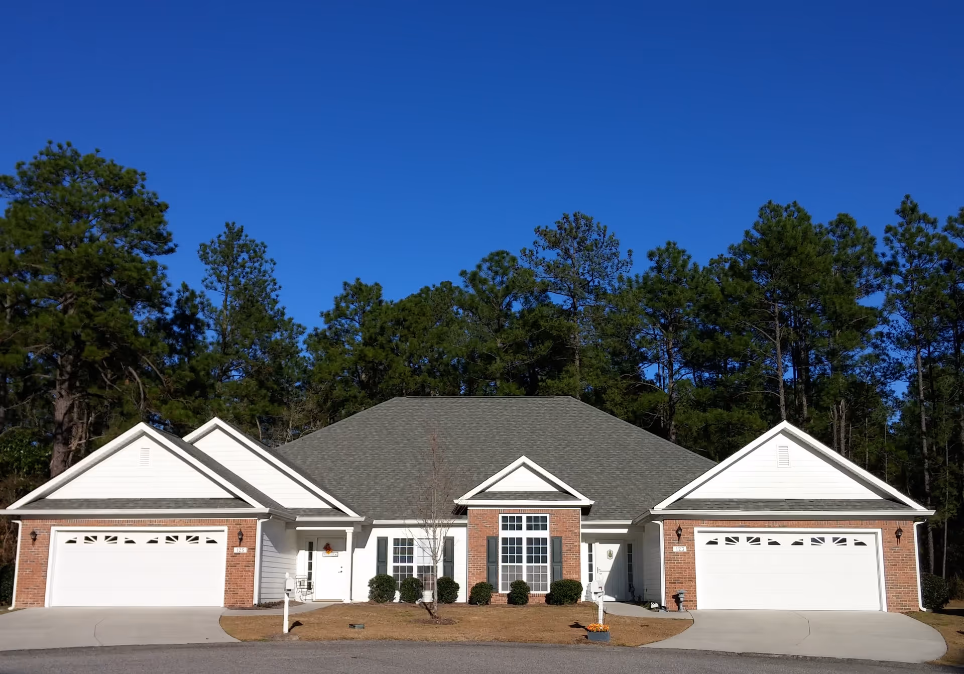 A single-story senior living facility with brick exterior and three garage bays.