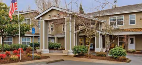 Exterior view of Brookdale River Road senior living facility entrance with columns and landscaping.