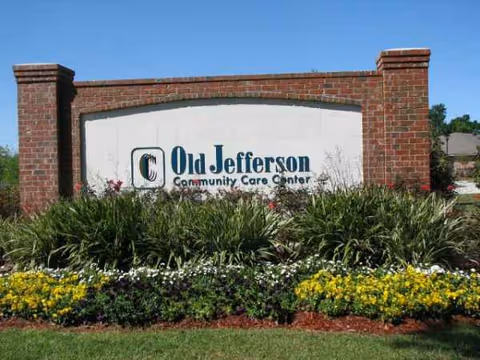 Brick entrance sign with columns displaying Old Jefferson Community Care Center and landscaping.