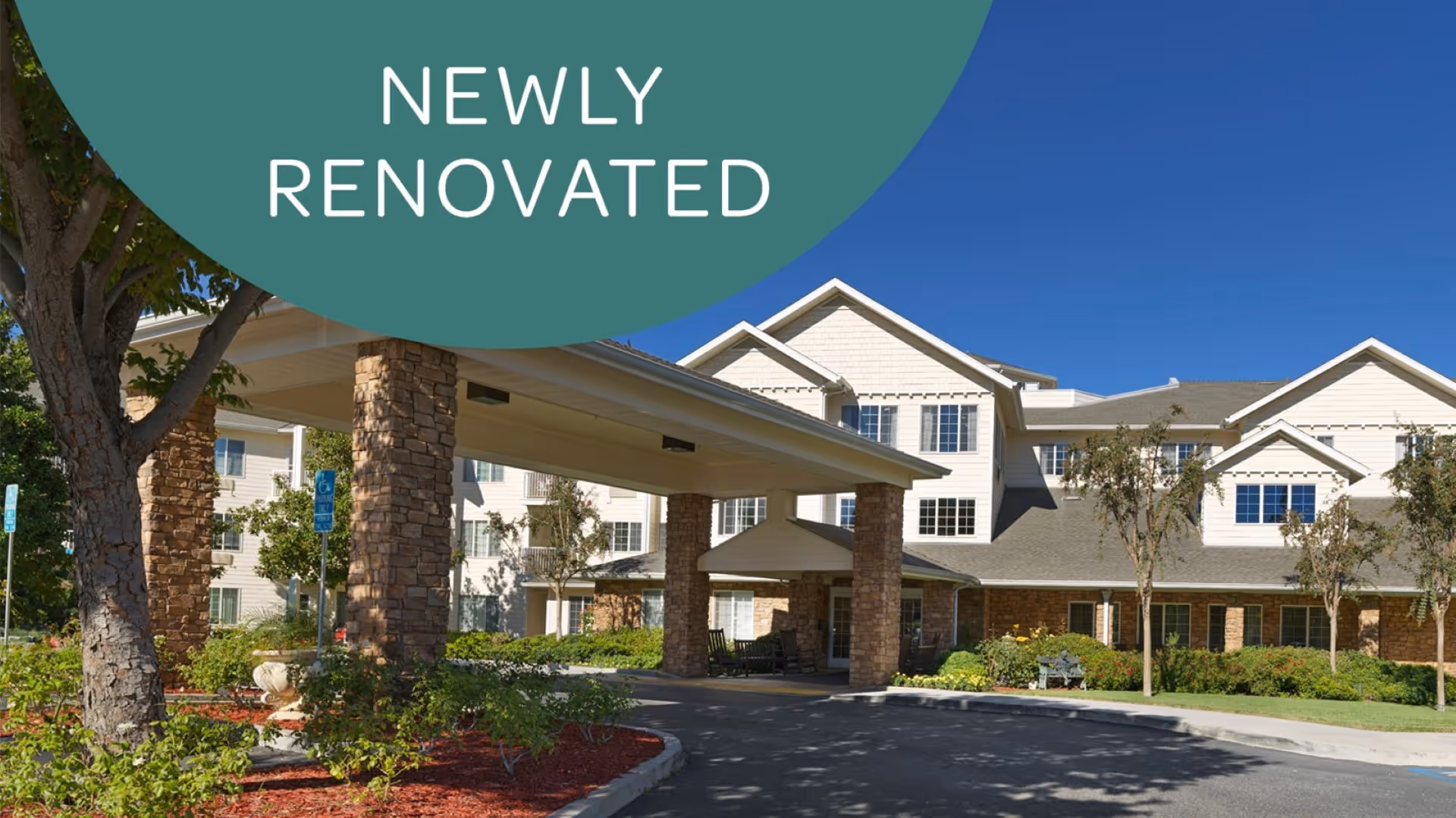 Exterior view of a senior living facility named Holiday Golden Oaks with a covered entrance supported by stone pillars, surrounded by trees and landscaping under a clear blue sky. A green semi-circle overlay in the top left corner contains the text 'NEWLY RENOVATED'.