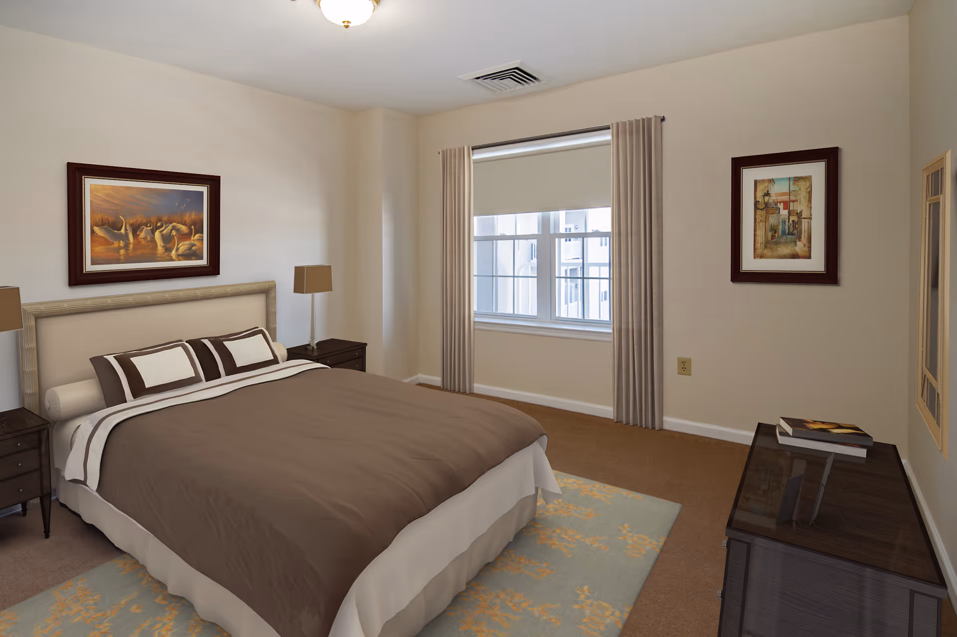 A neatly made bed with brown and beige bedding in a bedroom. The room has beige walls, a window with beige curtains, two framed pictures on the walls, two bedside tables with lamps, and a dresser with books on top.