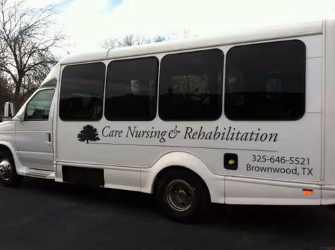 White passenger van labeled Care Nursing and Rehabilitation with logo and contact information.