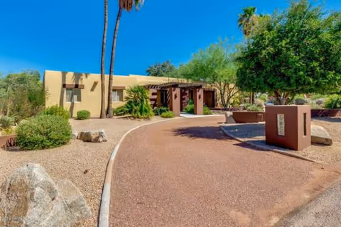 Desert landscaping lines a curved path to the Doubletree Ranchos Assisted Living building entrance.