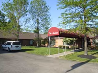 Exterior view of Briarfield Manor entrance with red awning and a parked car