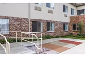 Exterior view of Monroeville Skilled Nursing and Rehabilitation Center entrance with brick facade and ramp.