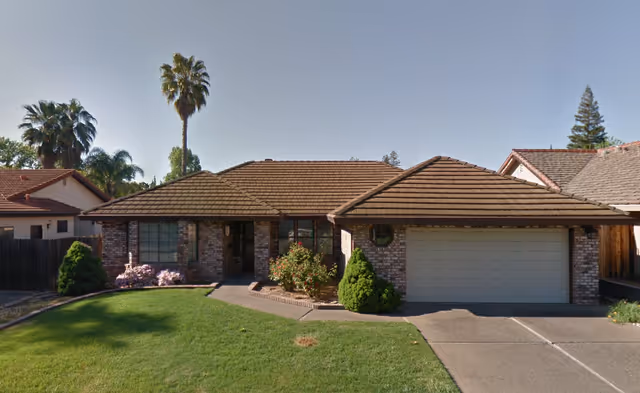 Front view of a single-story brick care home with a two-car garage