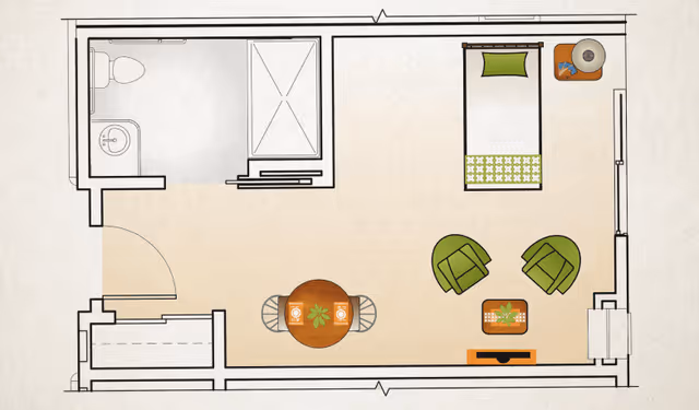 Floor plan of a small living space with a bathroom in the top left corner, a single bed in the top right corner, a round dining table with two chairs in the center left, and a seating area with two green chairs and a small table in the bottom right corner.