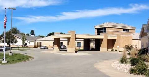 Exterior view of Park Place Memory Care facility with porte-cochere entrance and landscaping.