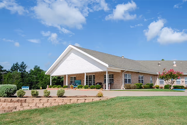Exterior view of Grayson Court senior living facility with brick walls and a covered entrance.